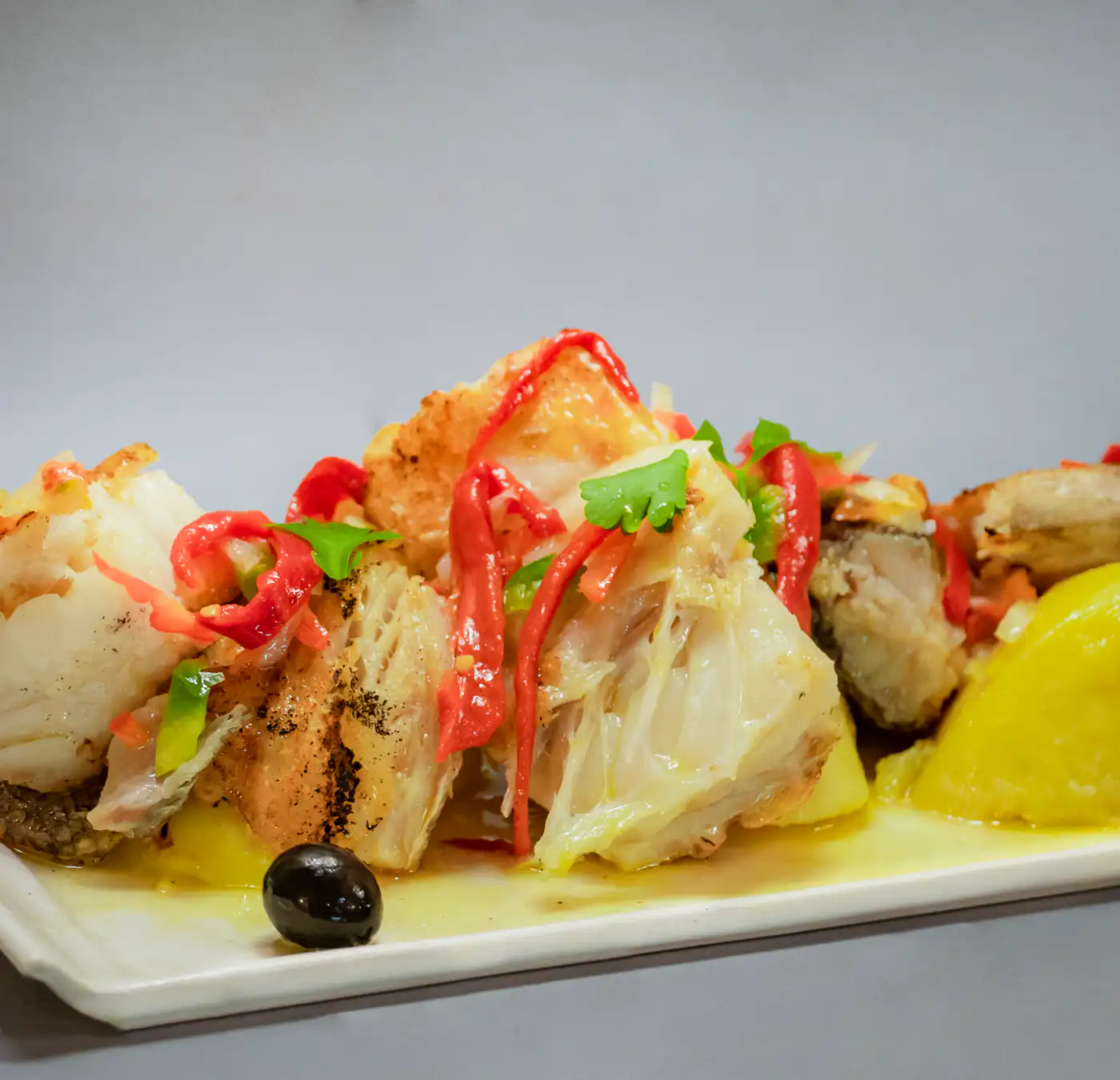 Bacalao con patata cocida y pimientos, una de las especialidades de Habemus Bouzas, cocina gallega en Bouzas, Vigo