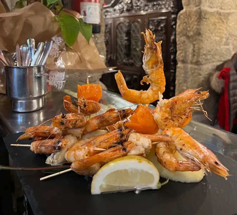 Brochetas de rape y langostinos a la plancha con limón, marisco fresco de cocina gallega en Habemus Bouzas, restaurante en Bouzas (Vigo)