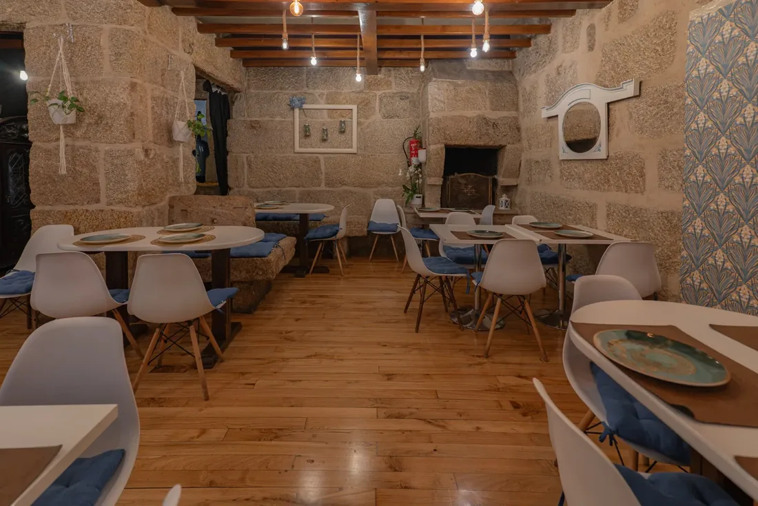 Comedor con chimenea de piedra en la tapería Habemus Bouzas
