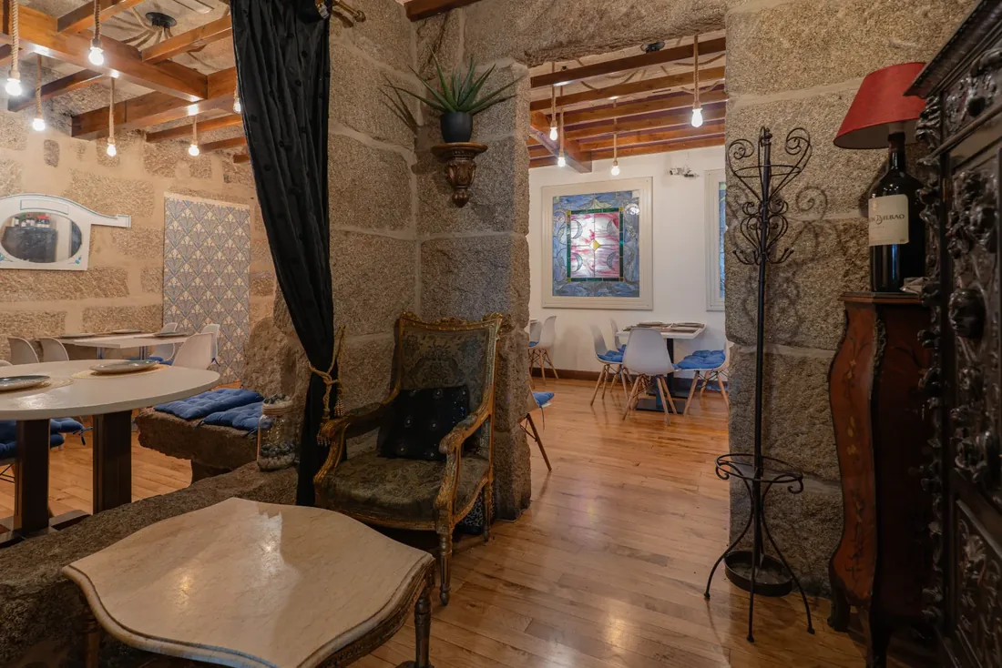 Interior de Habemus Bouzas con paredes de piedra y mobiliario antiguo, tapería en Bouzas (Vigo)